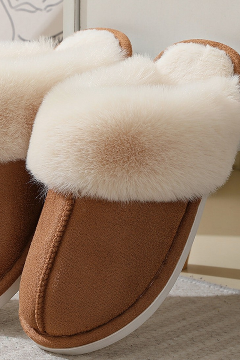Brown slippers with white fur lining on a neutral background