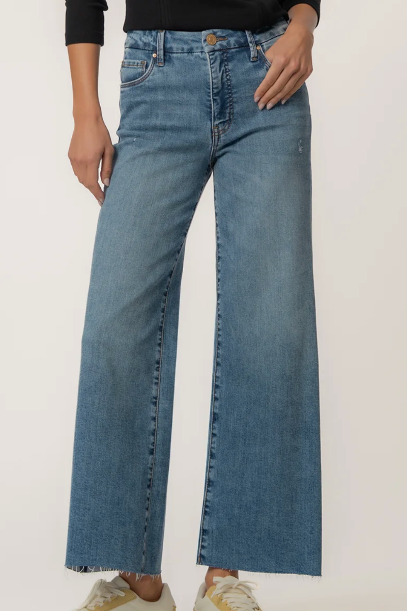 Person wearing blue wide-leg jeans on a plain background