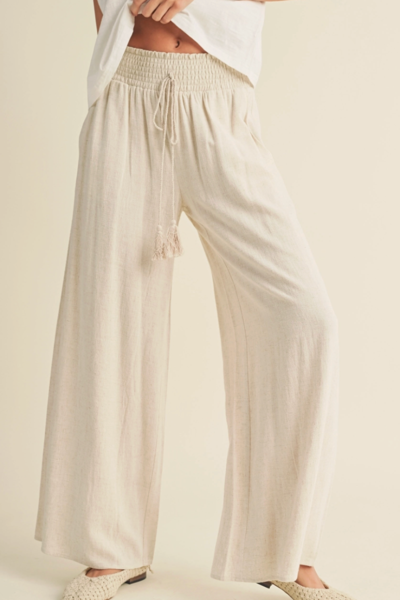 Beige wide-leg pants worn by a person on a plain background