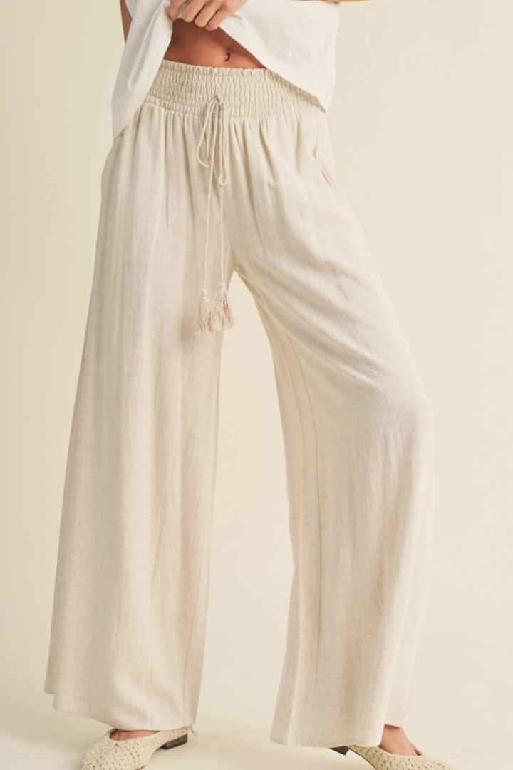Beige wide-leg pants worn by a person on a plain background