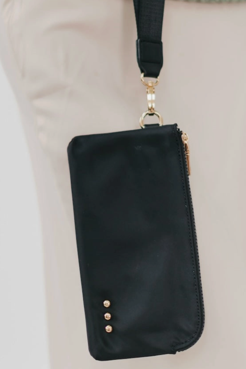 Black phone pouch with gold accents on a neutral background
