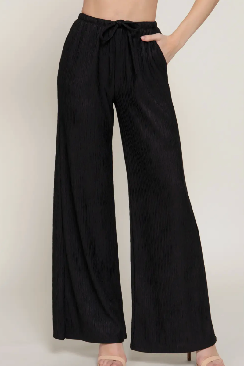 Black wide-leg pants worn by a person on a plain background