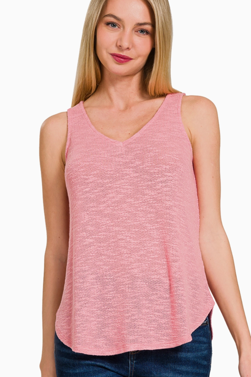 Woman wearing a pink sleeveless top against a white background