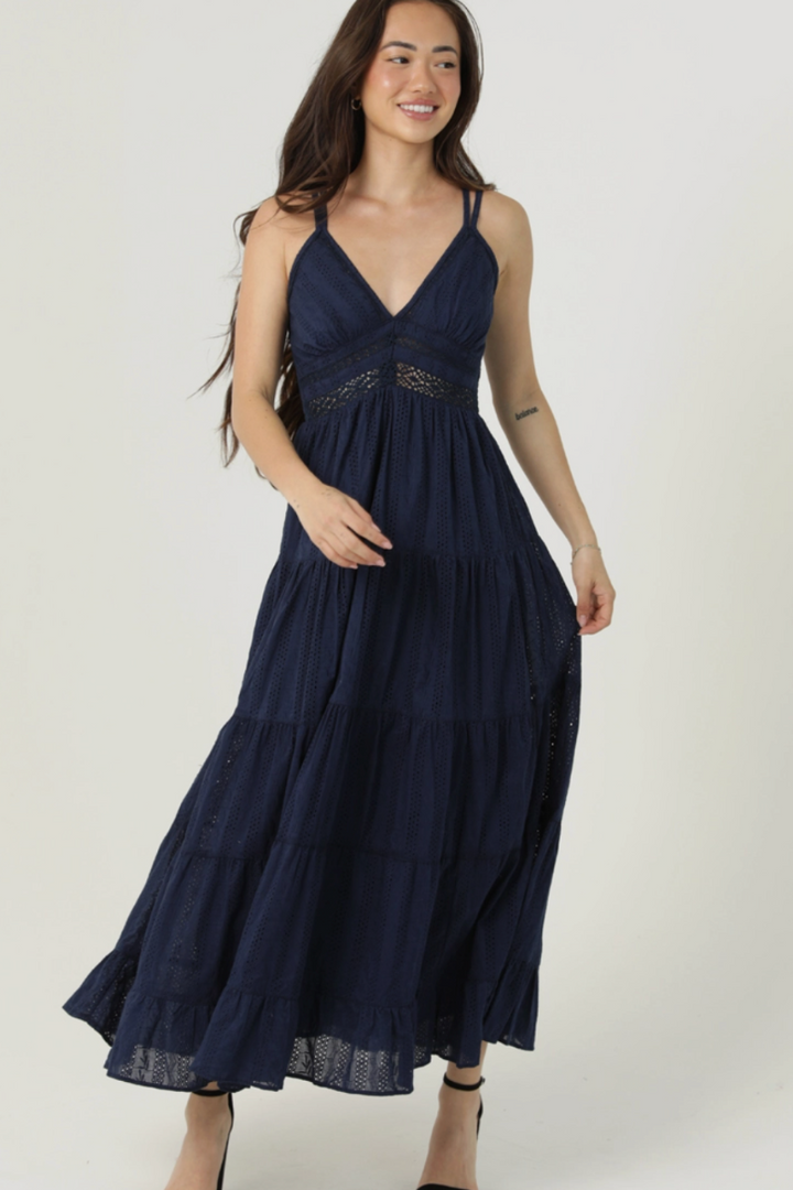 Woman wearing a navy blue dress against a white background
