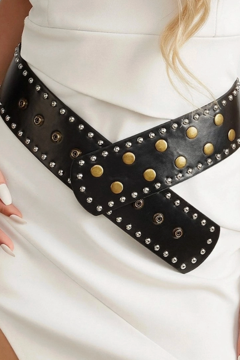 Black studded belt worn by a person on a white background