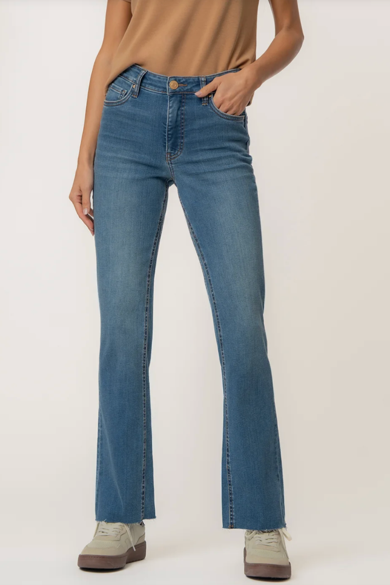 Person wearing ankle flare blue jeans on a plain background